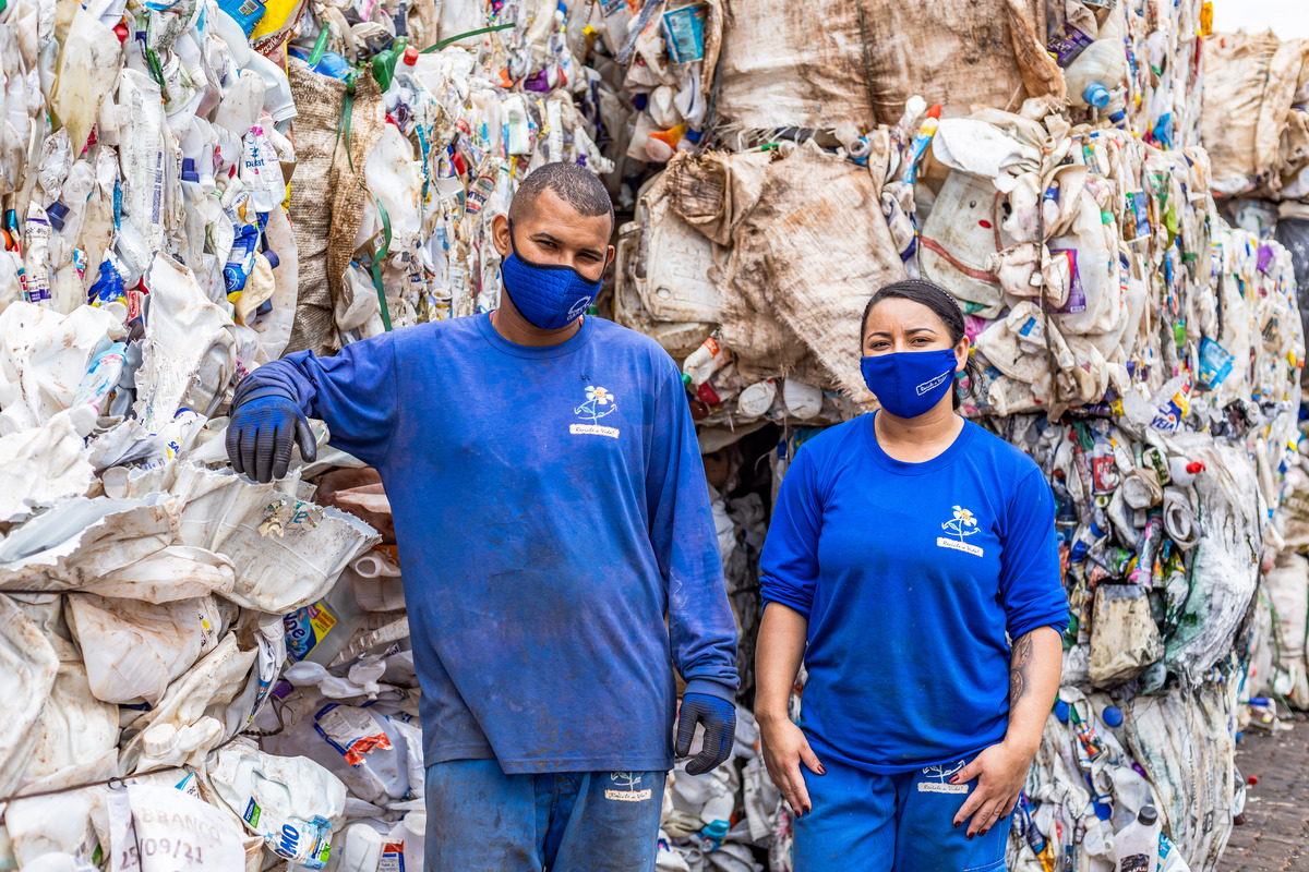 Um homem e uma mulher perto de fardos de material reciclado.